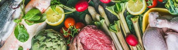 Assorted meat, fish and vegetables on chopping board