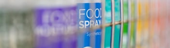 Close-up of Activate aerosol cans in wire-fronted cabinet